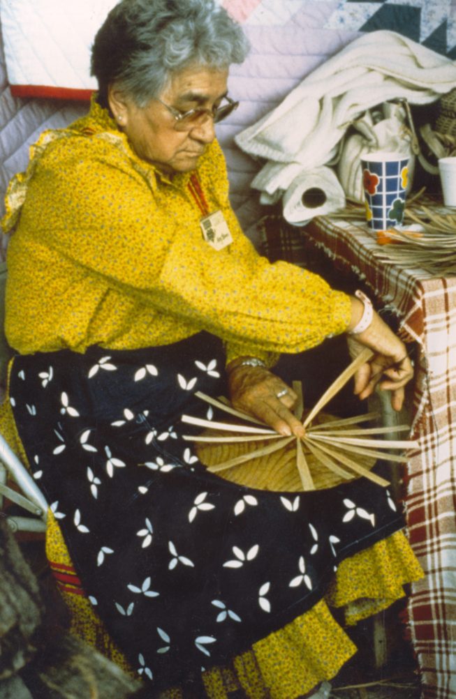 Akwesasne Mohawk ash splint and sweetgrass basket maker at work. Date and photographer unknown.