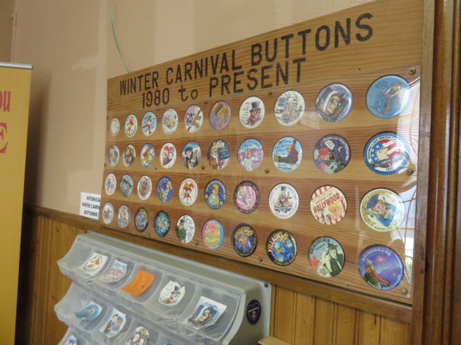 Saranac Lake Winter Carnival Buttons, 2018. Winter Carnival buttons are a beloved and long-standing tradition within the tradition of the event itself. Since 1981, Saranac Lake native and Doonesbury cartoon creator Gary Trudeau has been designing a different button for the carnival each year, and more recently collectable posters as well, which can be purchased at various locations around town.