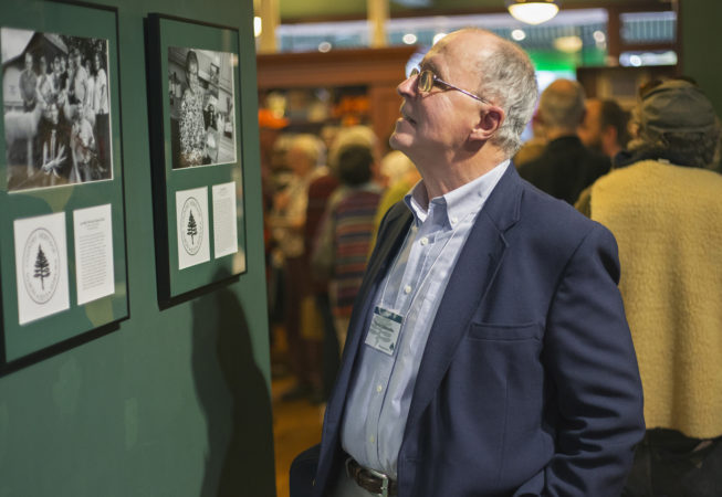 Varick Chittenden, TAUNY founder and folklorist, looks at profiles of the year's award recipients at The TAUNY Center, 2015.